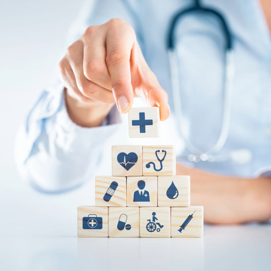 Doctor's hand stacking health-related blocks