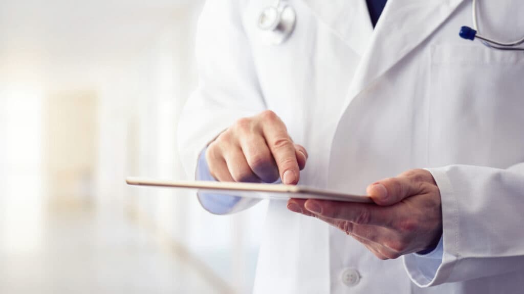 A doctor using a tablet for a consultation